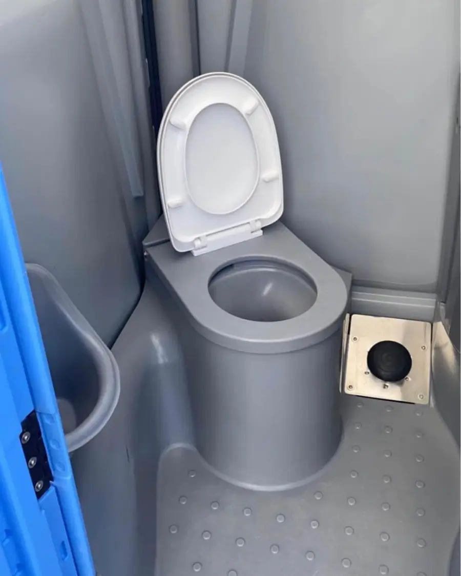 Flushing toilet seat inside a deluxe portable restroom