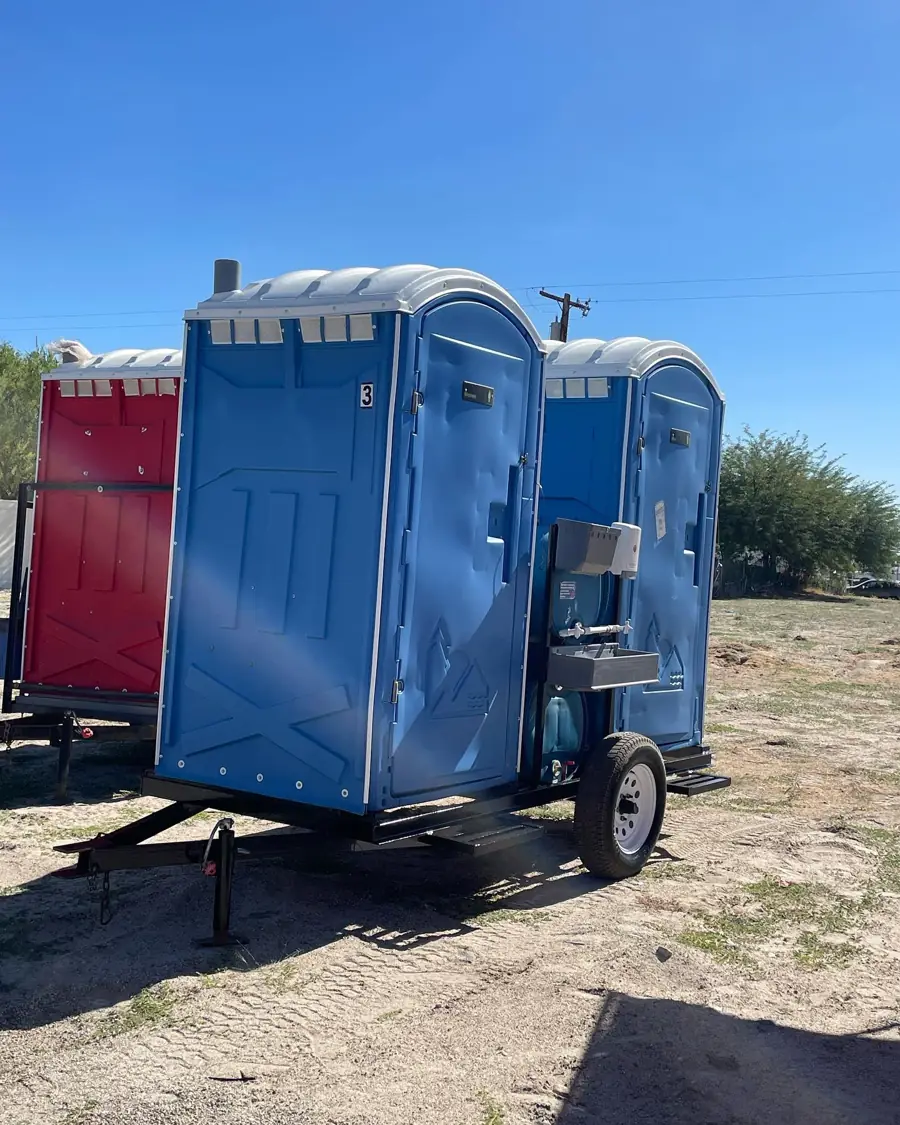 Towable porta potty trailer parked at an open jobsite